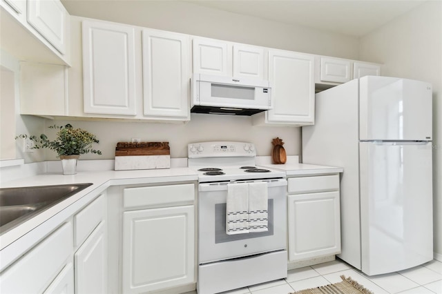 kitchen featuring white appliances, light tile patterned floors, and white cabinets