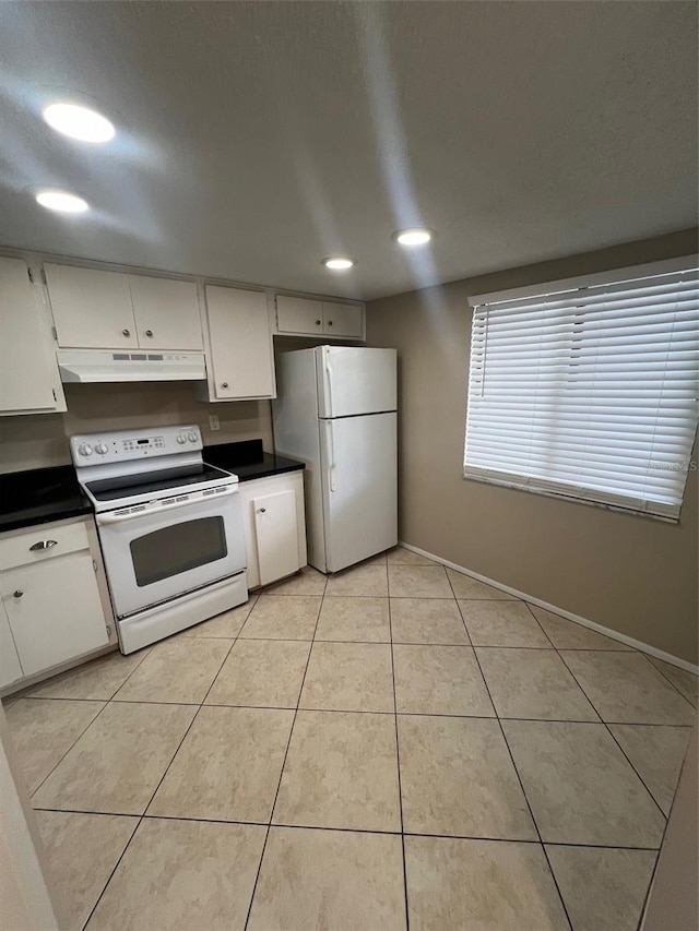 kitchen with white cabinets, light tile patterned flooring, and white appliances