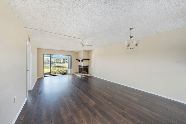 unfurnished living room with ceiling fan, a textured ceiling, and dark hardwood / wood-style flooring