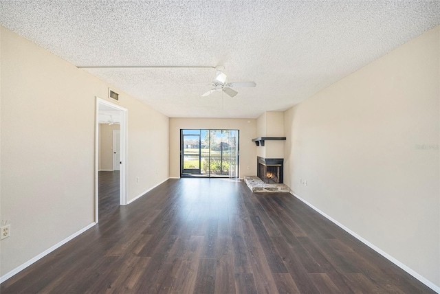 unfurnished living room featuring ceiling fan, dark hardwood / wood-style flooring, and a textured ceiling