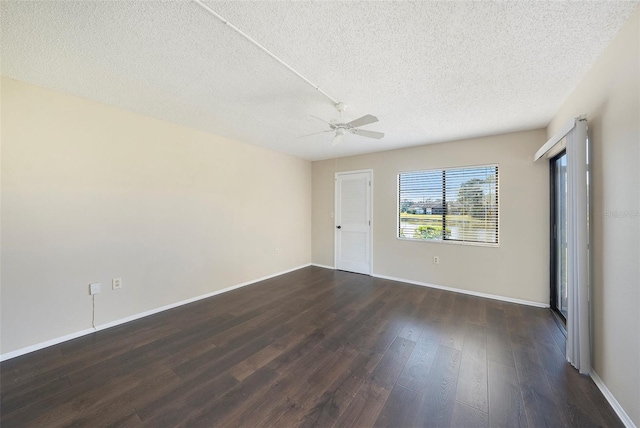 empty room with ceiling fan, dark wood-type flooring, and a textured ceiling