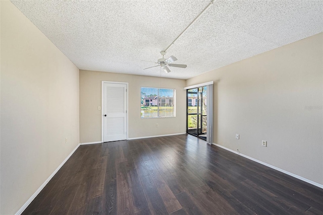 spare room with a textured ceiling, dark wood-type flooring, and ceiling fan