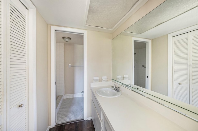 bathroom featuring hardwood / wood-style flooring, vanity, and walk in shower