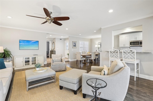 living room with hardwood / wood-style flooring, ceiling fan, and crown molding