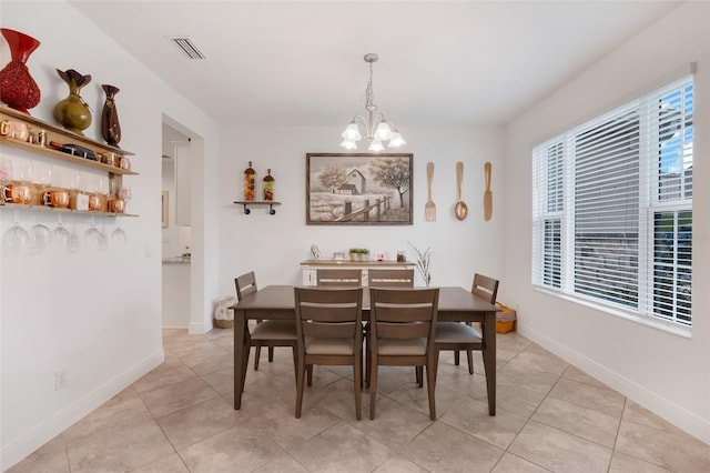 tiled dining room with a chandelier