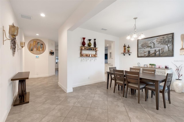 tiled dining space featuring an inviting chandelier