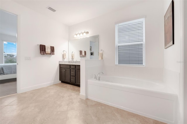 bathroom featuring a tub, tile patterned flooring, and vanity