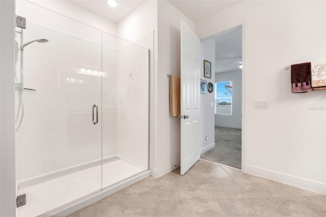 bathroom featuring ceiling fan and a shower with shower door