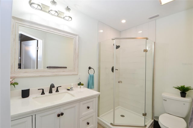 bathroom with an enclosed shower, vanity, and toilet