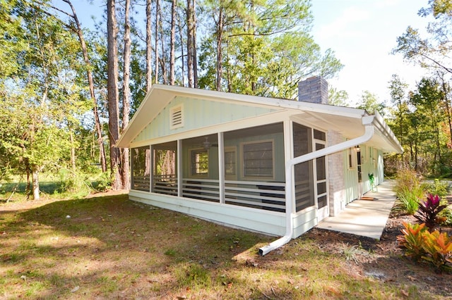 view of property exterior with a sunroom and a yard