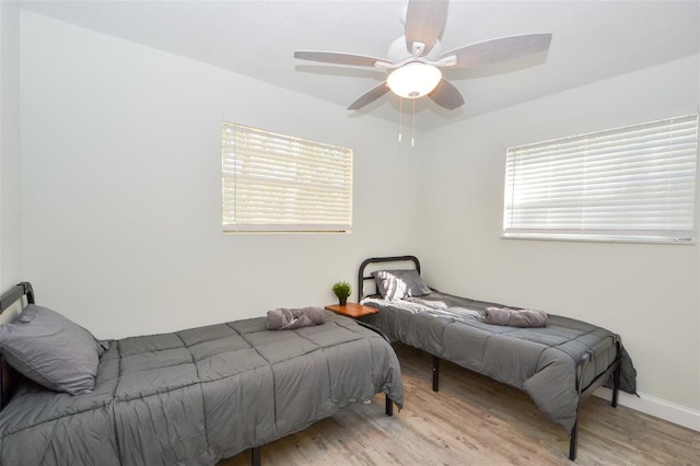 bedroom featuring multiple windows, ceiling fan, and light hardwood / wood-style floors