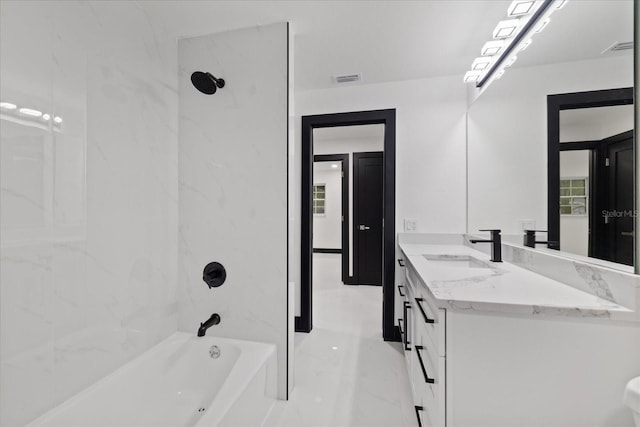 bathroom featuring tiled shower / bath and vanity