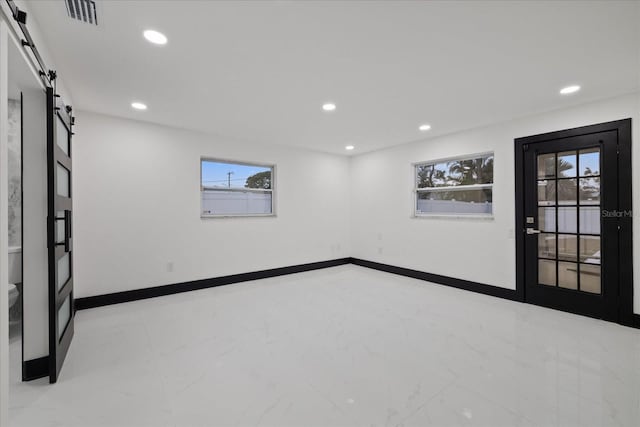 unfurnished room with a barn door