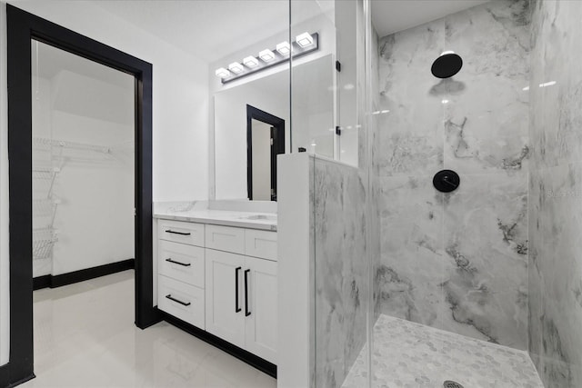 bathroom with a tile shower and vanity