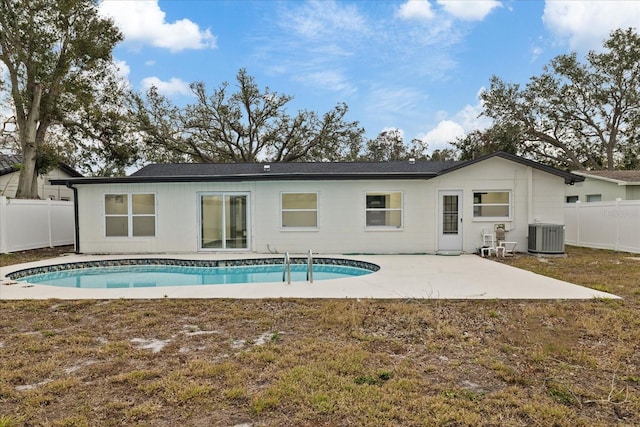 rear view of house featuring a patio area, central AC, and a fenced in pool