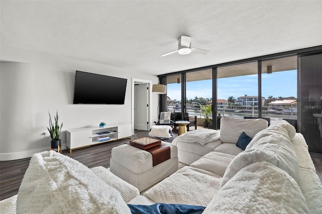 living room with a wall of windows, a textured ceiling, dark hardwood / wood-style floors, and ceiling fan