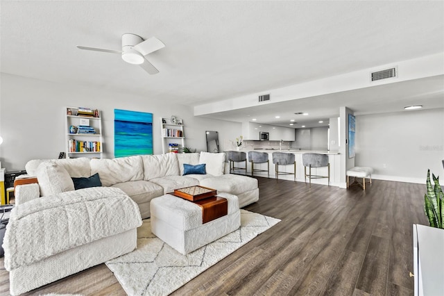 living room with hardwood / wood-style flooring, ceiling fan, and sink