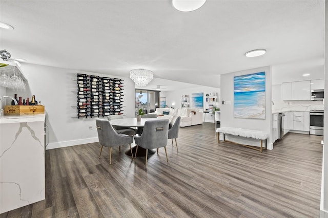 dining room with dark hardwood / wood-style floors, a notable chandelier, and sink