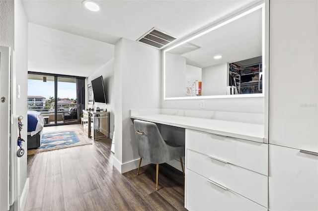 office space featuring built in desk and dark wood-type flooring