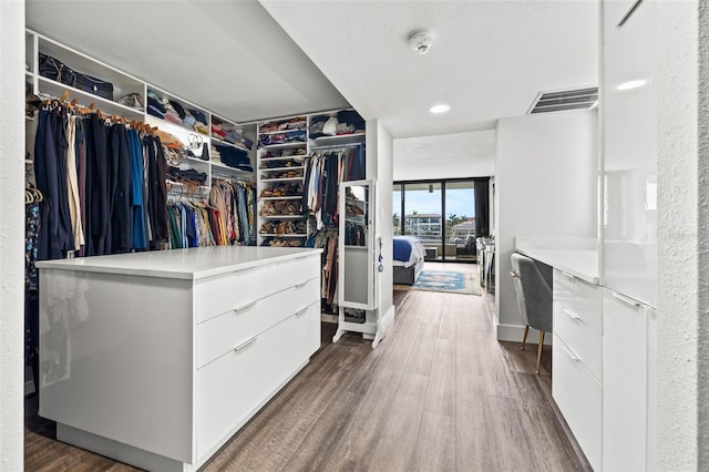 spacious closet with dark hardwood / wood-style flooring