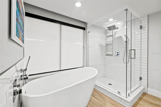 bathroom with separate shower and tub and wood-type flooring