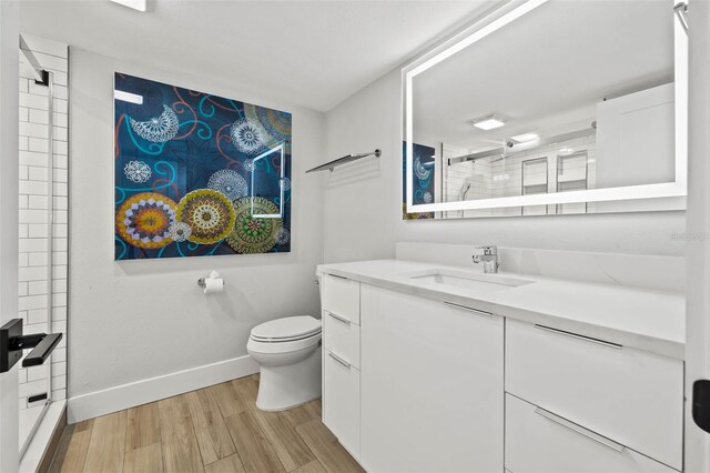 bathroom featuring vanity, toilet, wood-type flooring, and walk in shower