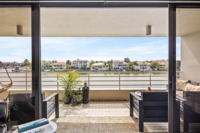 view of patio with a balcony and a water view