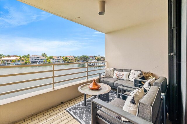 balcony featuring an outdoor living space and a water view