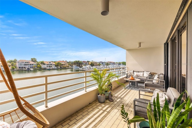 balcony featuring outdoor lounge area and a water view