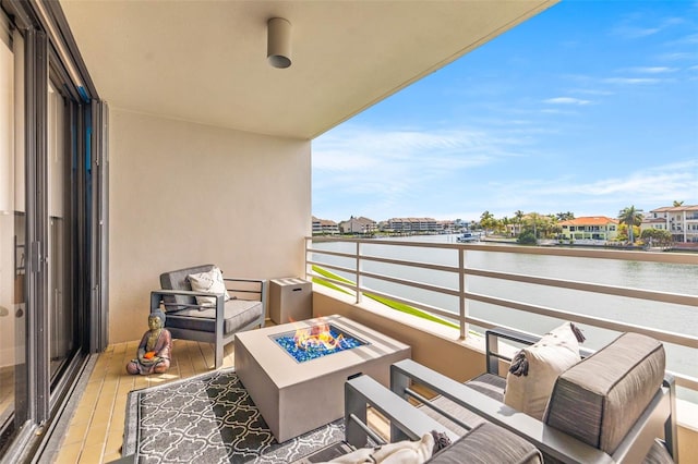 balcony featuring a water view and a fire pit