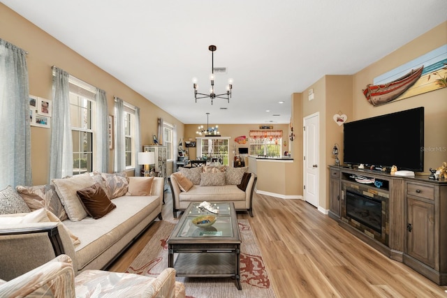 living room with light wood-type flooring and an inviting chandelier