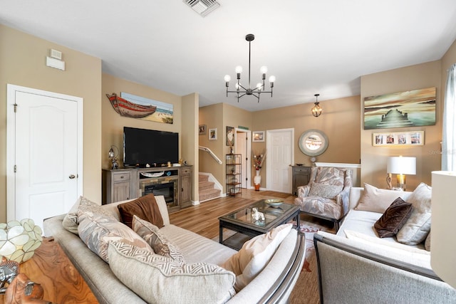 living room with a notable chandelier and light hardwood / wood-style flooring