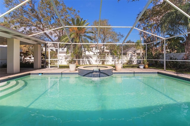 view of pool with an in ground hot tub and glass enclosure