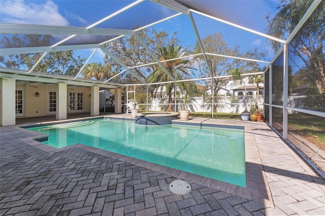 view of pool with a patio, an in ground hot tub, ceiling fan, and glass enclosure