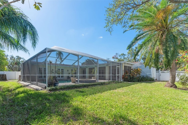 rear view of property featuring a fenced in pool, a lanai, and a yard