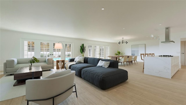 living room with crown molding, french doors, a chandelier, and light wood-type flooring