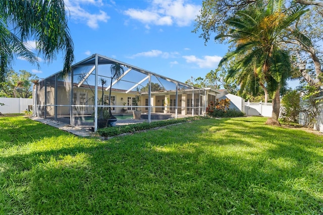 view of yard with a fenced in pool and glass enclosure