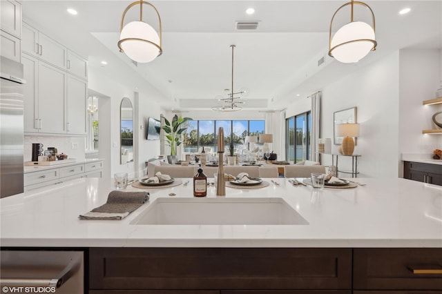 kitchen with white cabinets, decorative light fixtures, and plenty of natural light