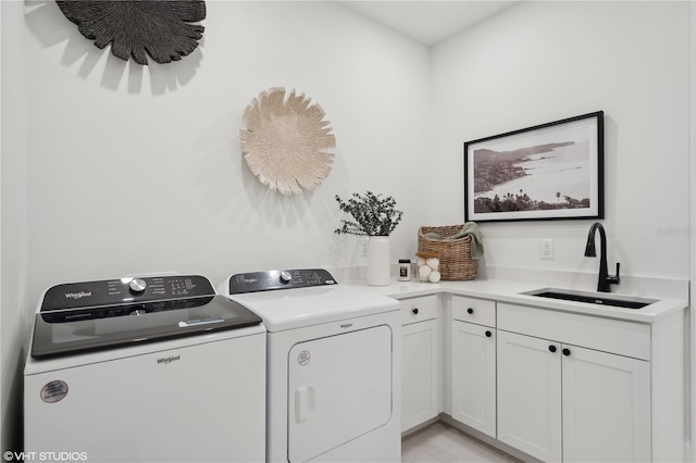 laundry room with washing machine and dryer, sink, and cabinets