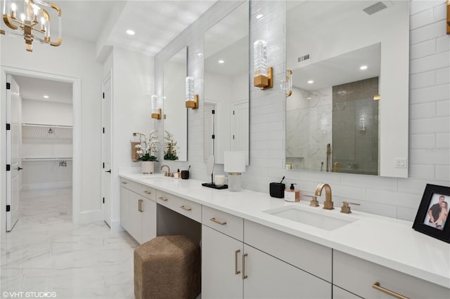 bathroom featuring a shower with door and vanity