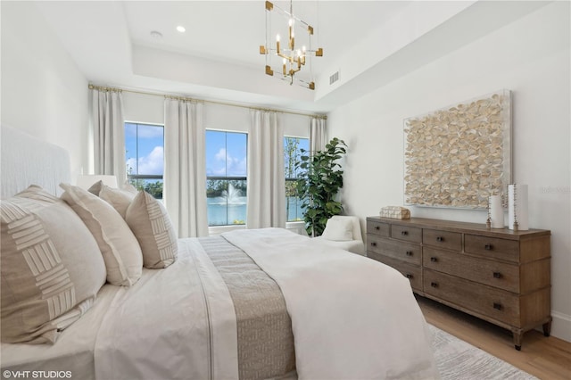 bedroom featuring a notable chandelier and light hardwood / wood-style flooring