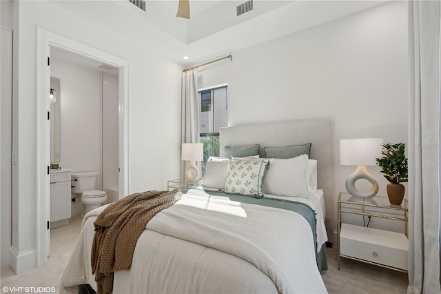 bedroom featuring light carpet, connected bathroom, and ceiling fan