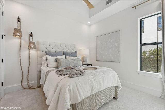 carpeted bedroom featuring ceiling fan and multiple windows