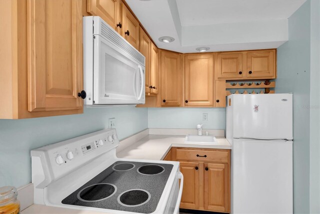 kitchen featuring white appliances and sink