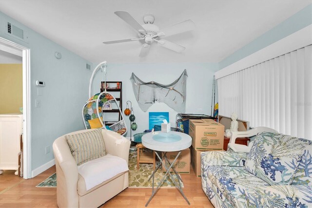 living area with ceiling fan and light wood-type flooring