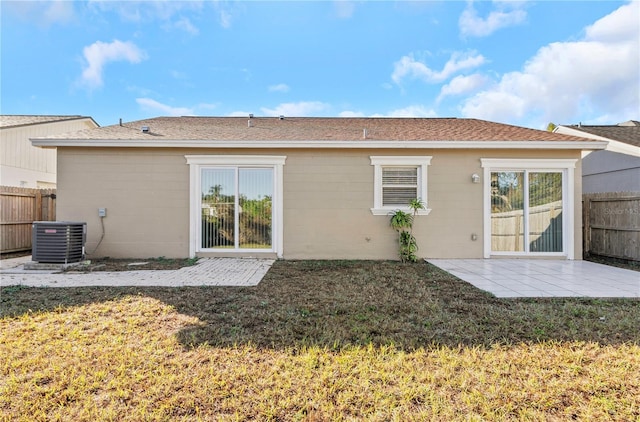 rear view of property featuring central air condition unit, a patio area, and a yard