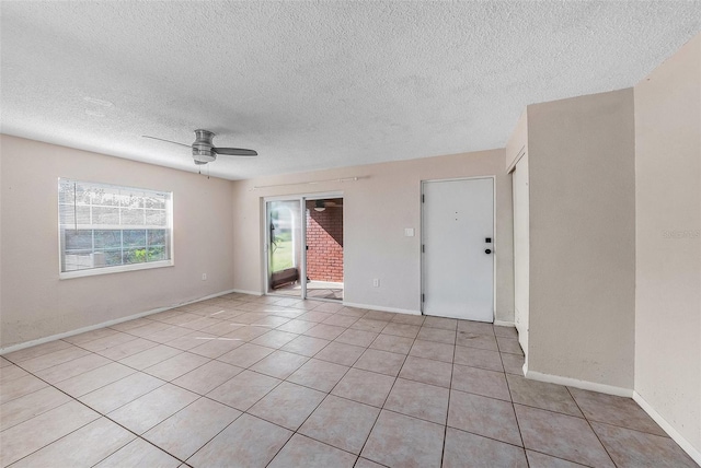 spare room with light tile patterned floors, a textured ceiling, and ceiling fan