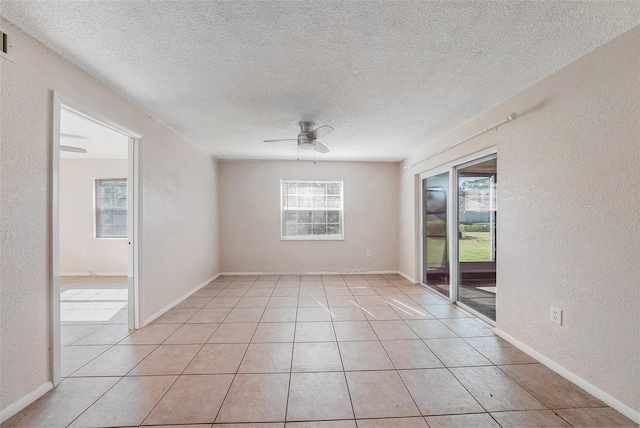 spare room with light tile patterned floors, a textured ceiling, and ceiling fan