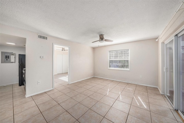 tiled empty room featuring ceiling fan and a textured ceiling