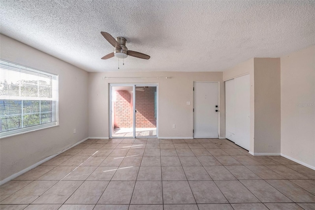 tiled spare room with ceiling fan and a textured ceiling